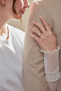 Close-up of a hand wearing a diamond ring on a blurred background