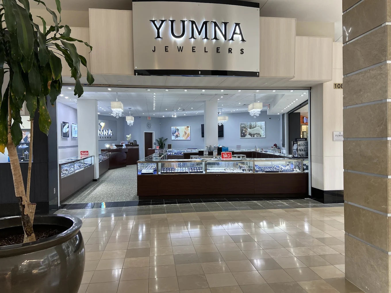 YUMNA Jewelers store inside a mall with a sign above the entrance.